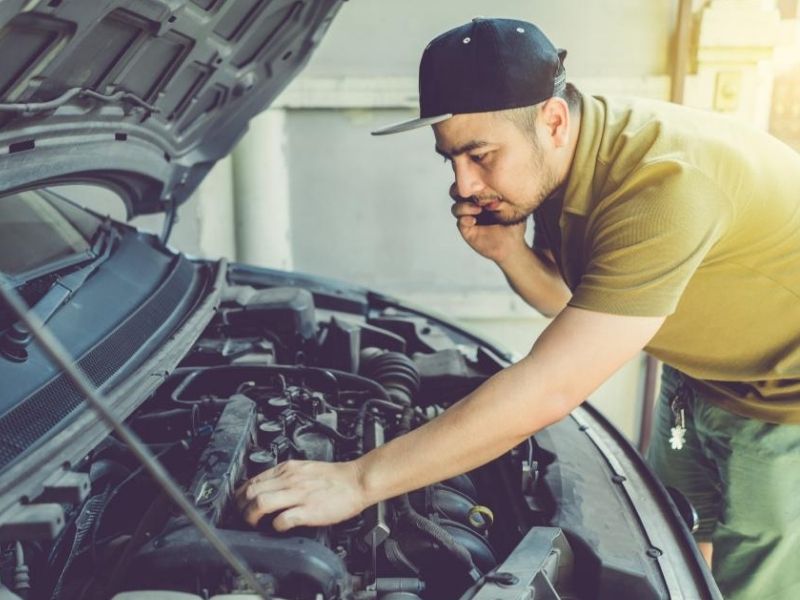 man fixing car engine